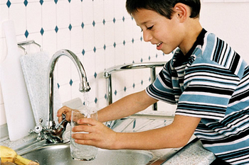 Imgebild: Junge mit einem Glas Wasser aus dem Wasserhahn